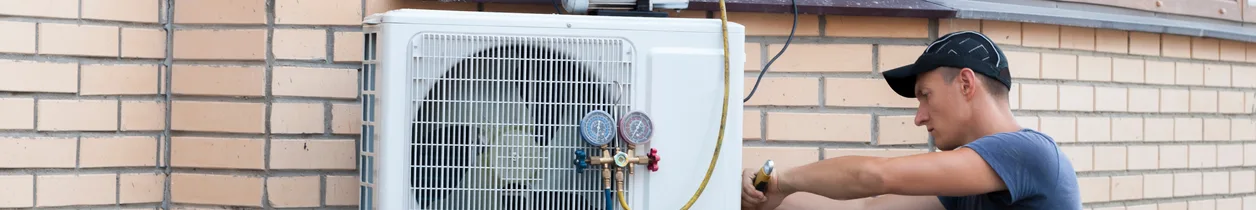 A Superior technician servicing an outdoor AC condenser